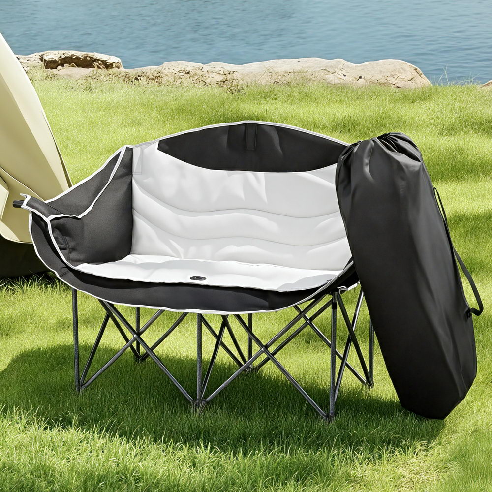 Folding outdoor chair with carrying bag on grass near water