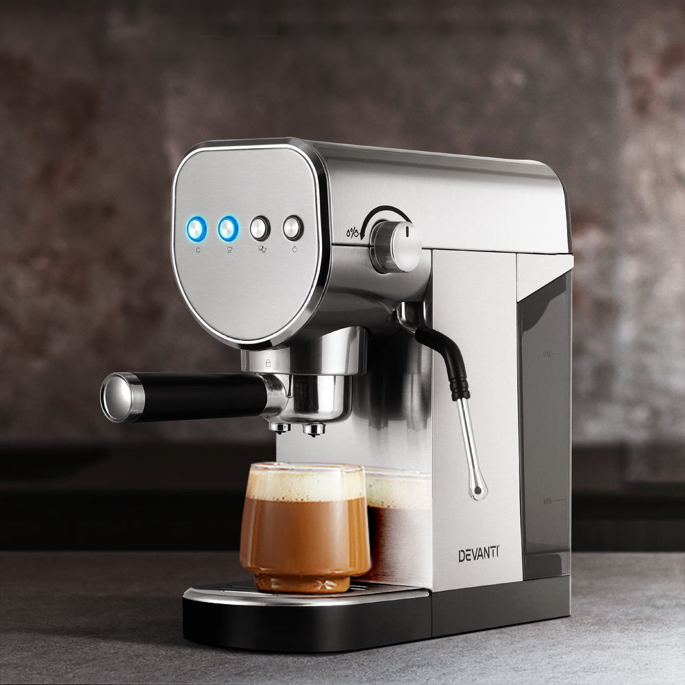 Silver espresso machine with a glass of coffee on a dark surface