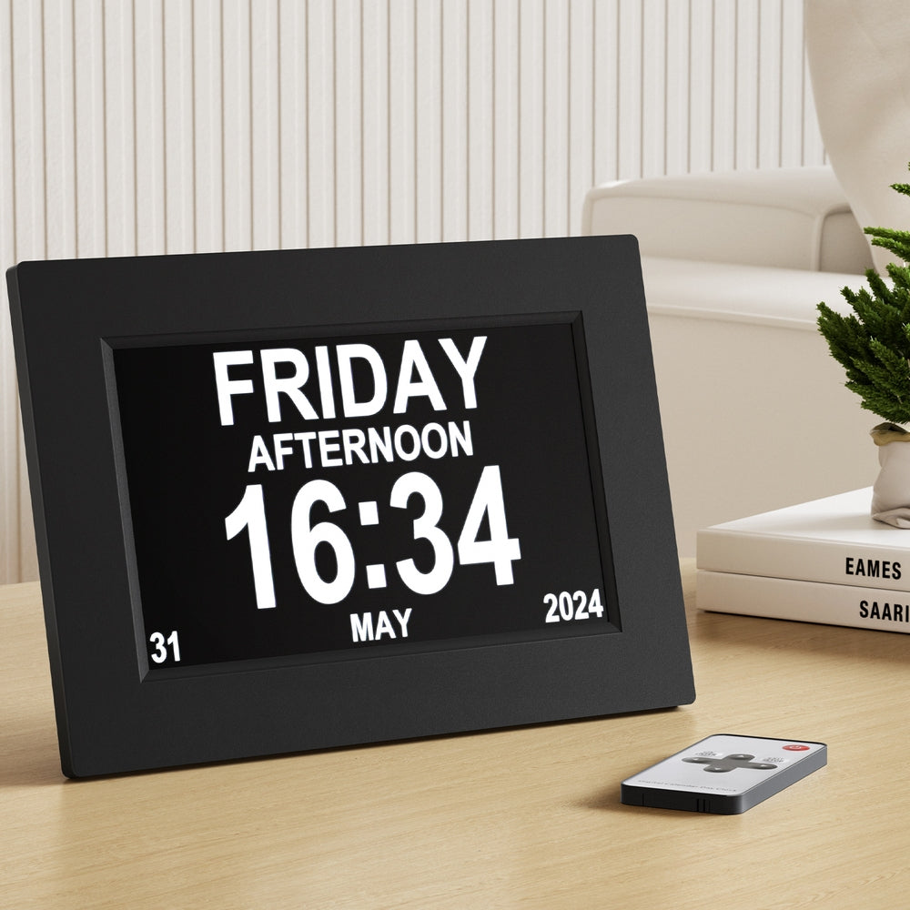 Digital clock displaying date and time on a table with a remote control.