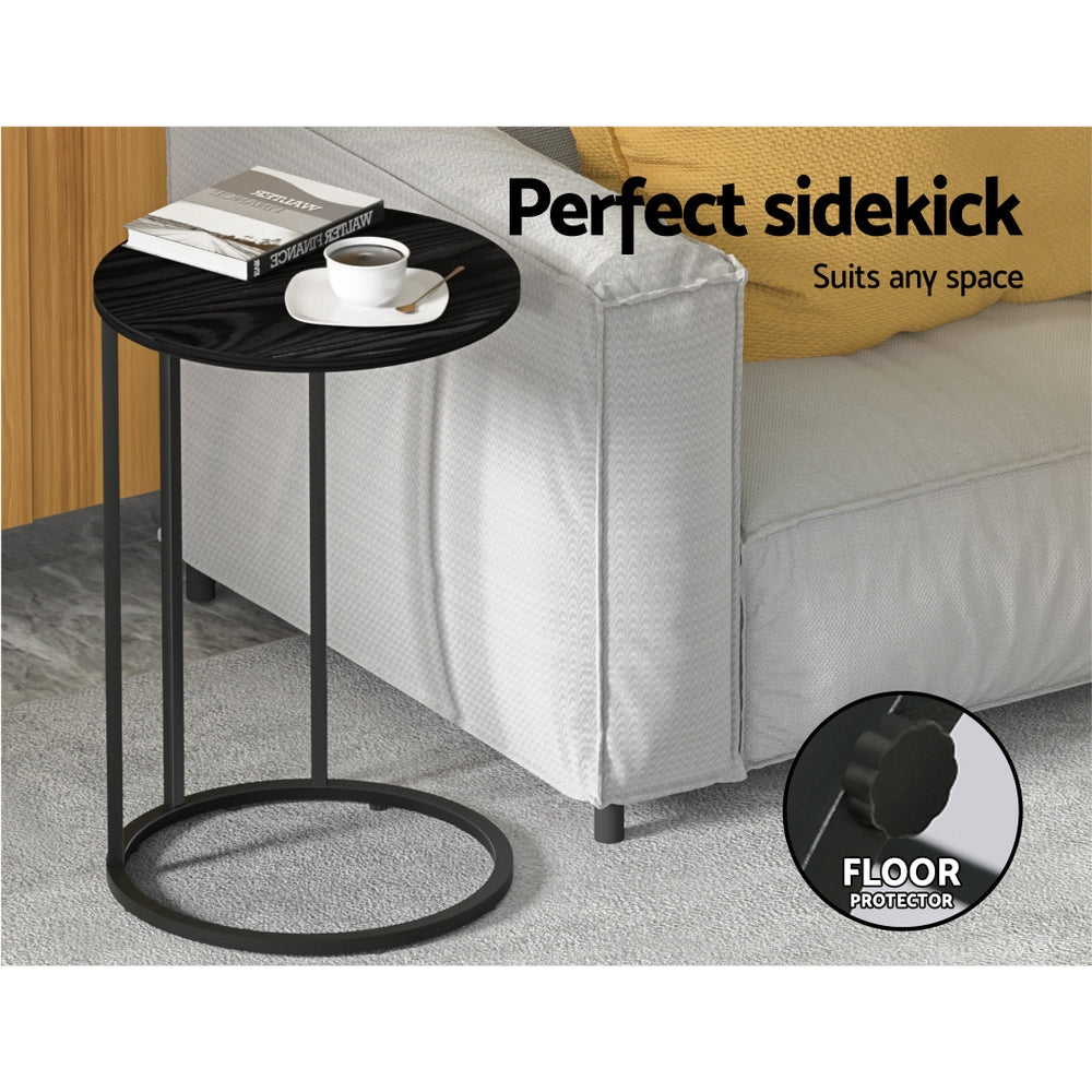 Black side table with books and a cup next to a gray sofa, with text 'Perfect sidekick Suits any space' and 'FLOOR PROTECTOR'.