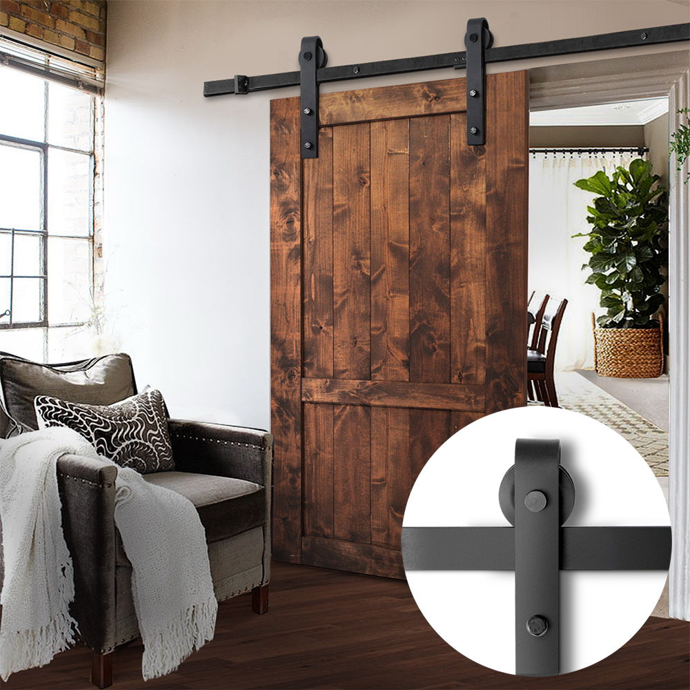 Wooden sliding barn door in a home interior with a close-up of the door's roller mechanism.