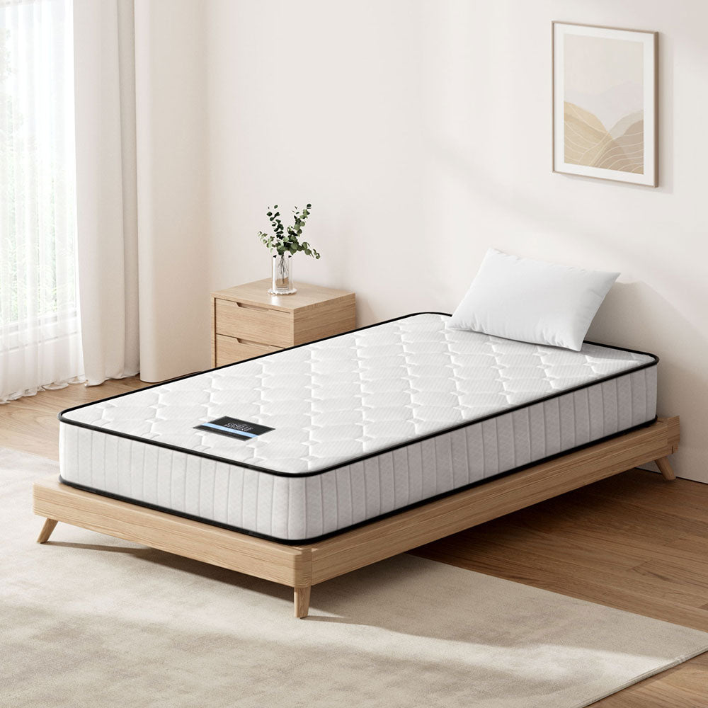 Mattress on a wooden bed frame in a bedroom setting