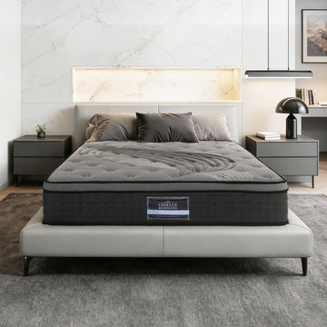 Gray mattress on a bed in a bedroom setting with nightstands and decor.