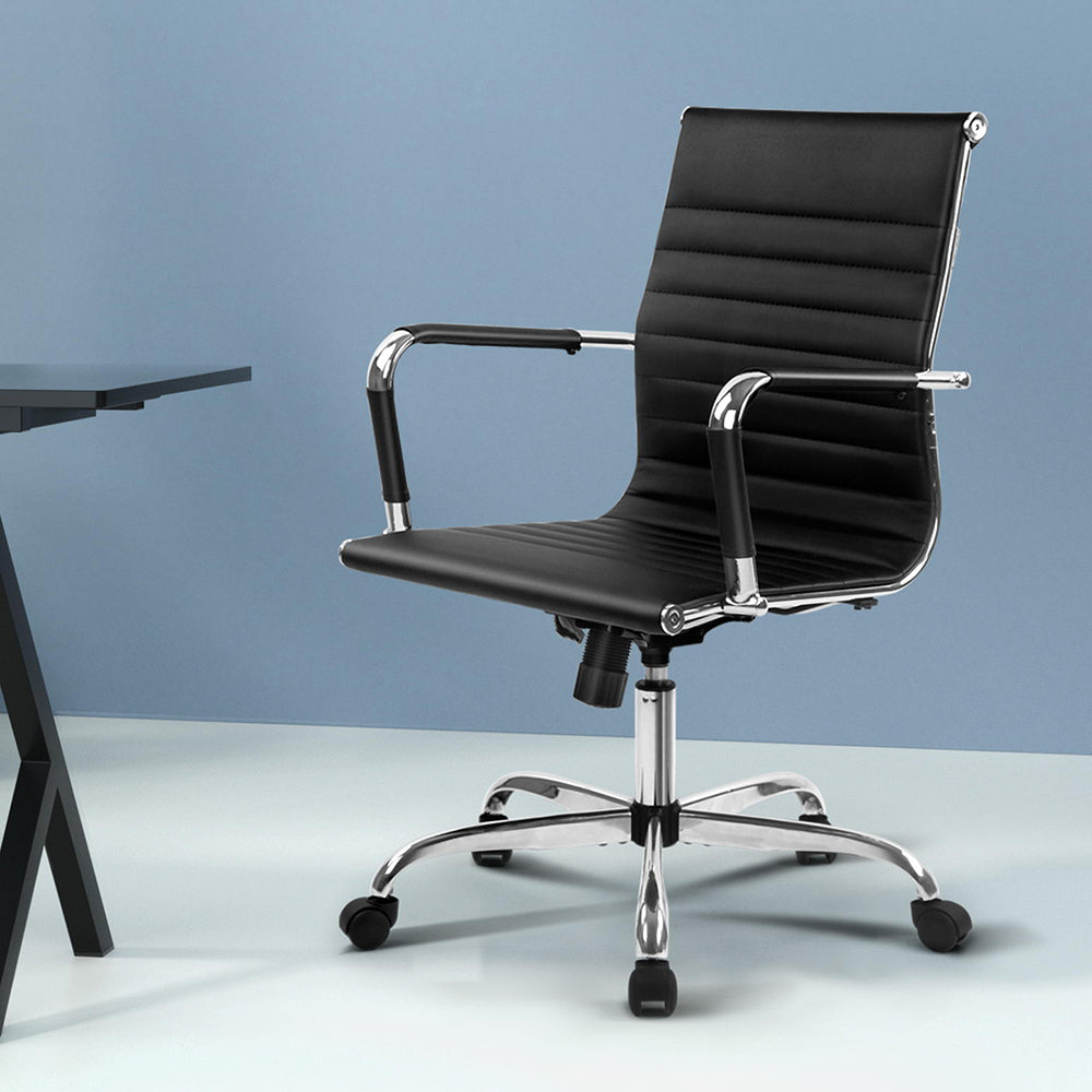 Black office chair with chrome accents on a light blue background