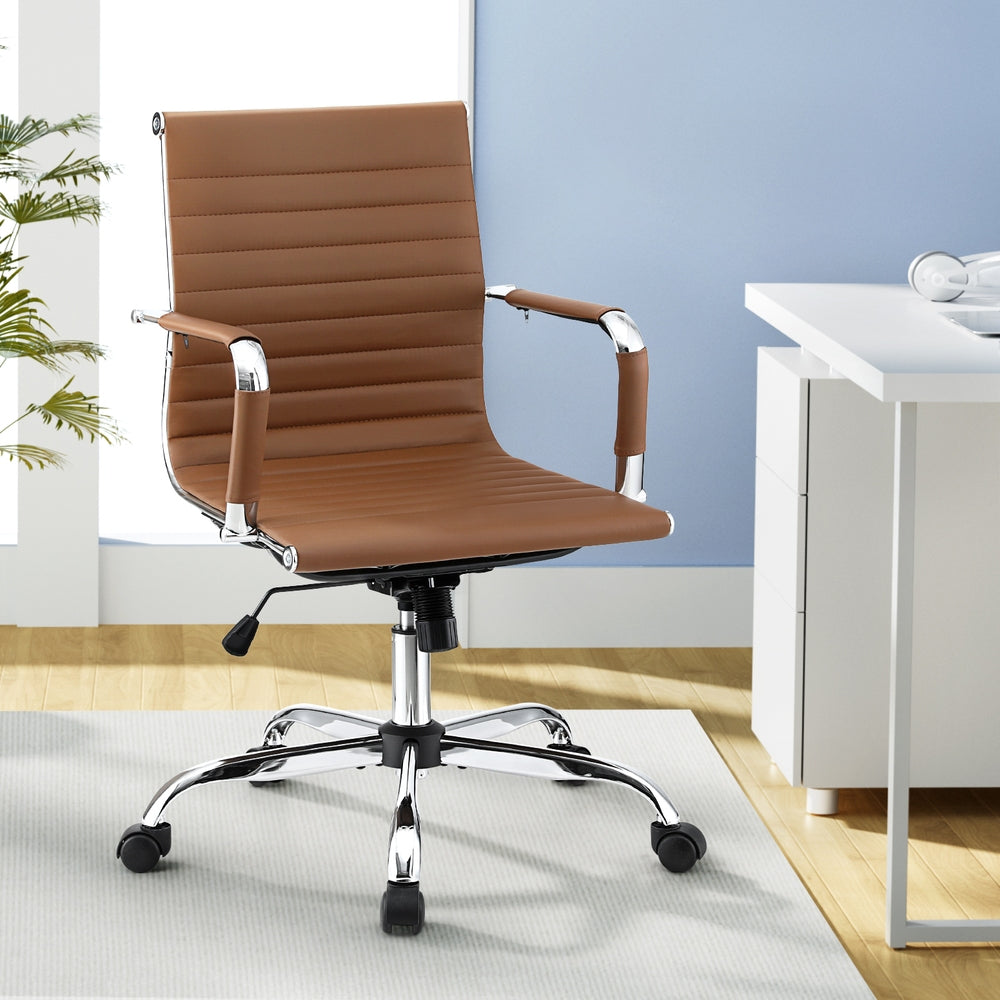 Brown office chair in a modern office setting with a desk and plant.