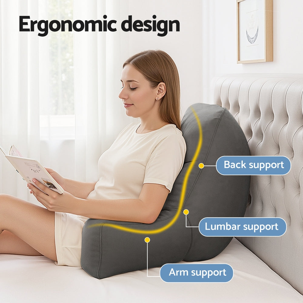 Woman using an ergonomic back support pillow on a couch, with labeled support points.