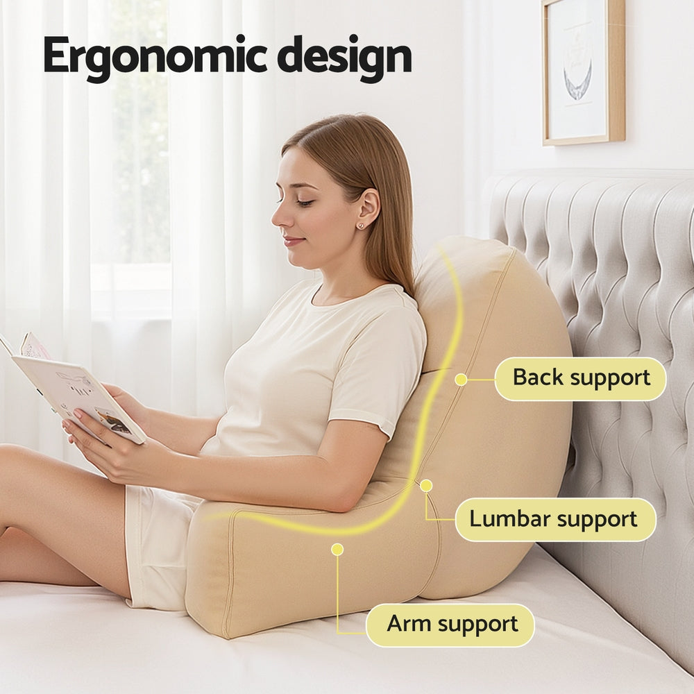 Woman using an ergonomic backrest with labeled support points in a bedroom setting.