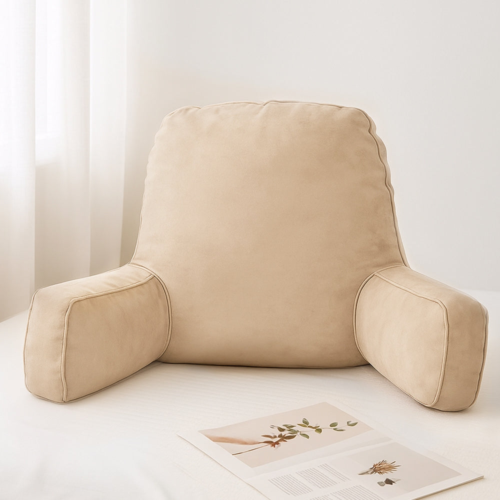 Beige reading pillow on a white surface with a light background