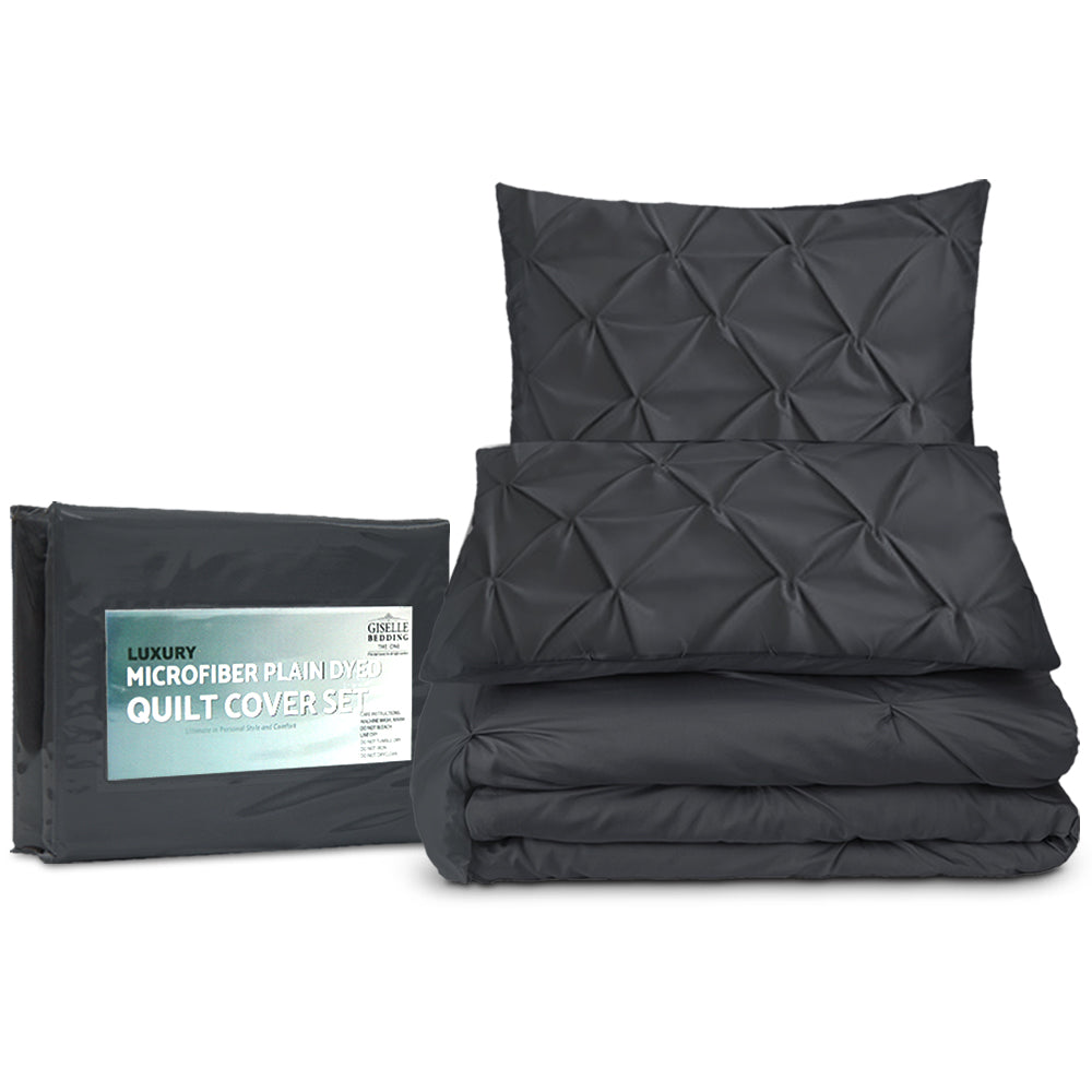 Black quilt cover set with pillowcases and packaging on a white background