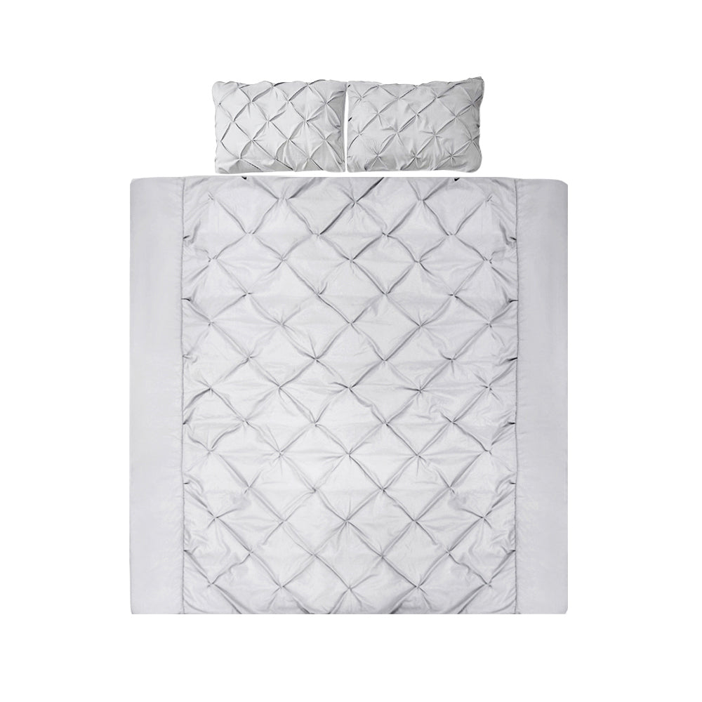 Quilted bedspread with diamond pattern and matching pillow on a white background