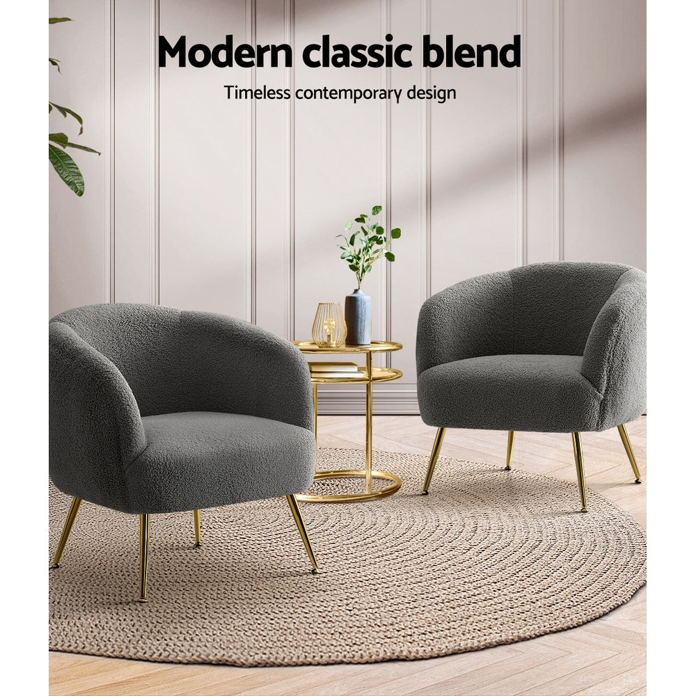 Two gray armchairs with gold legs in a room with a round rug and small table.