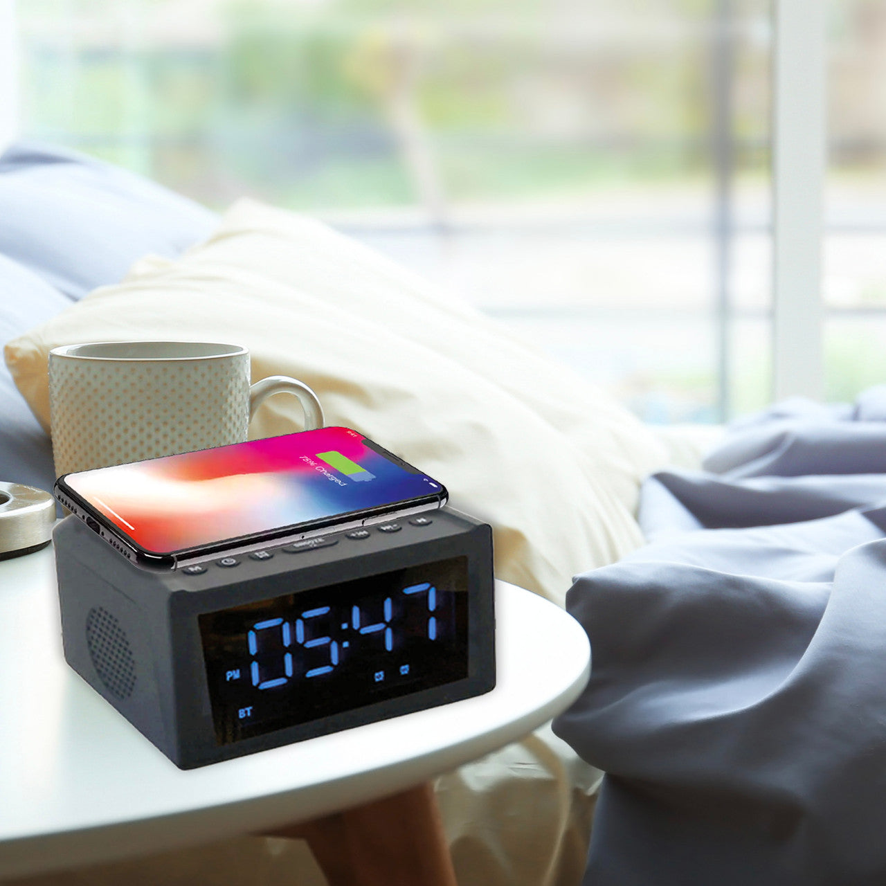 Digital clock with smartphone on a nightstand in a bedroom setting