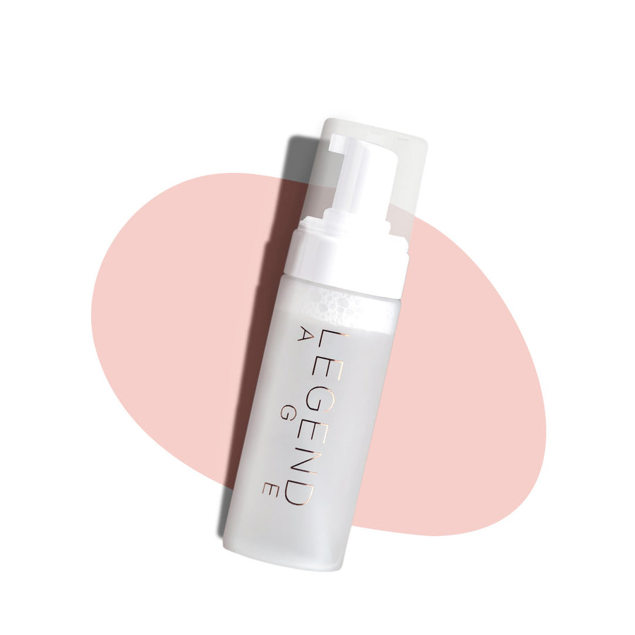 Skincare bottle labeled 'Legend' on a white background with a pink circular design.