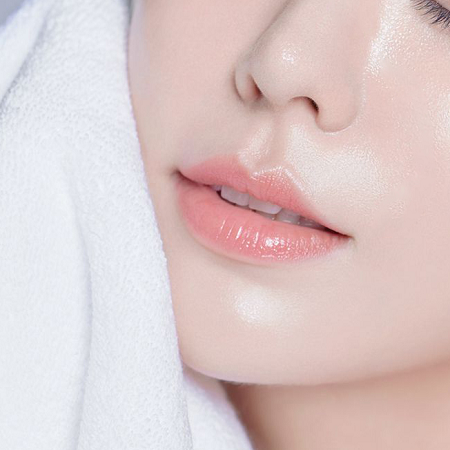 Close-up of a person's lips with a white towel in the background