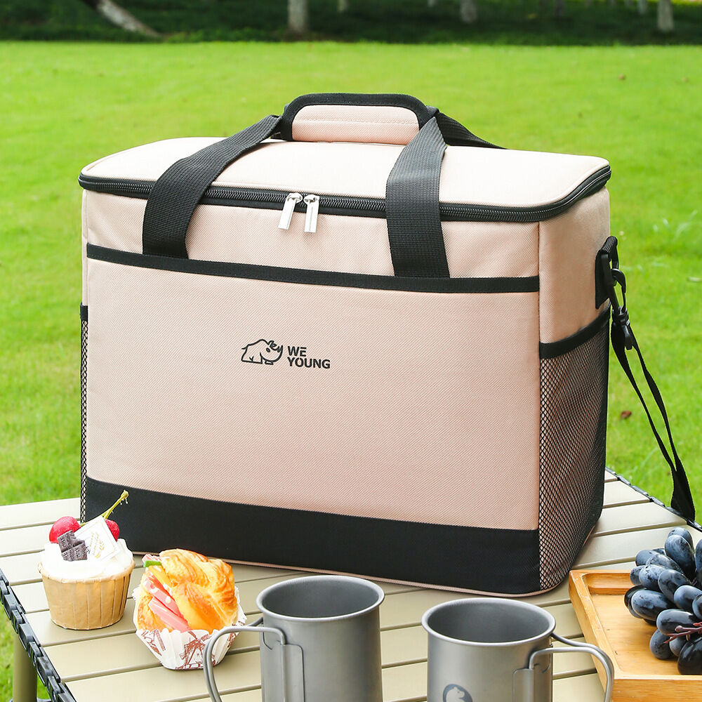 Beige cooler bag with black accents on a wooden table outdoors