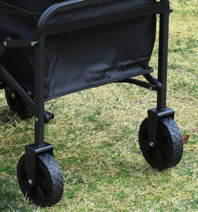 Black stroller with large wheels on a grassy background