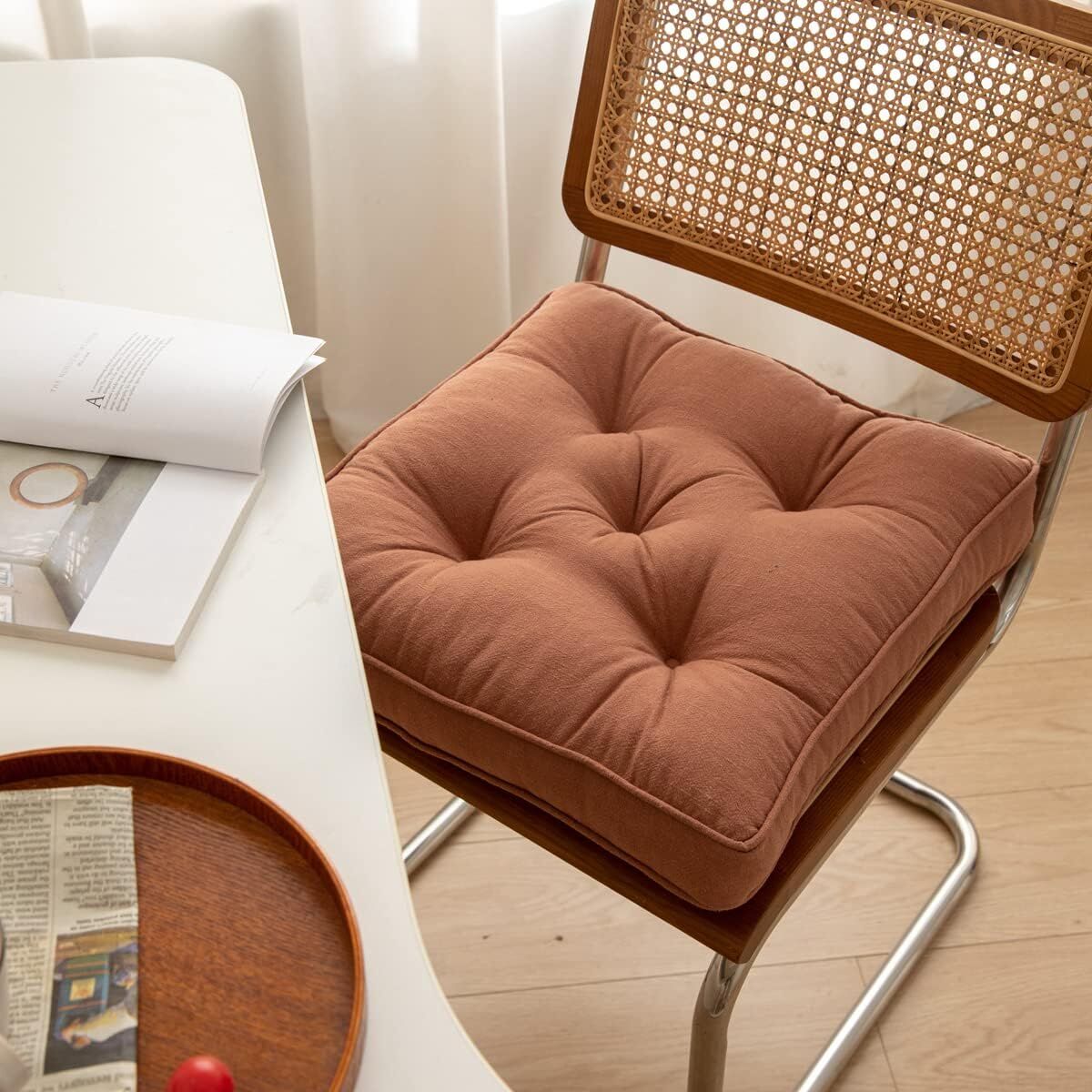 Brown cushion on a chair next to a table with a magazine