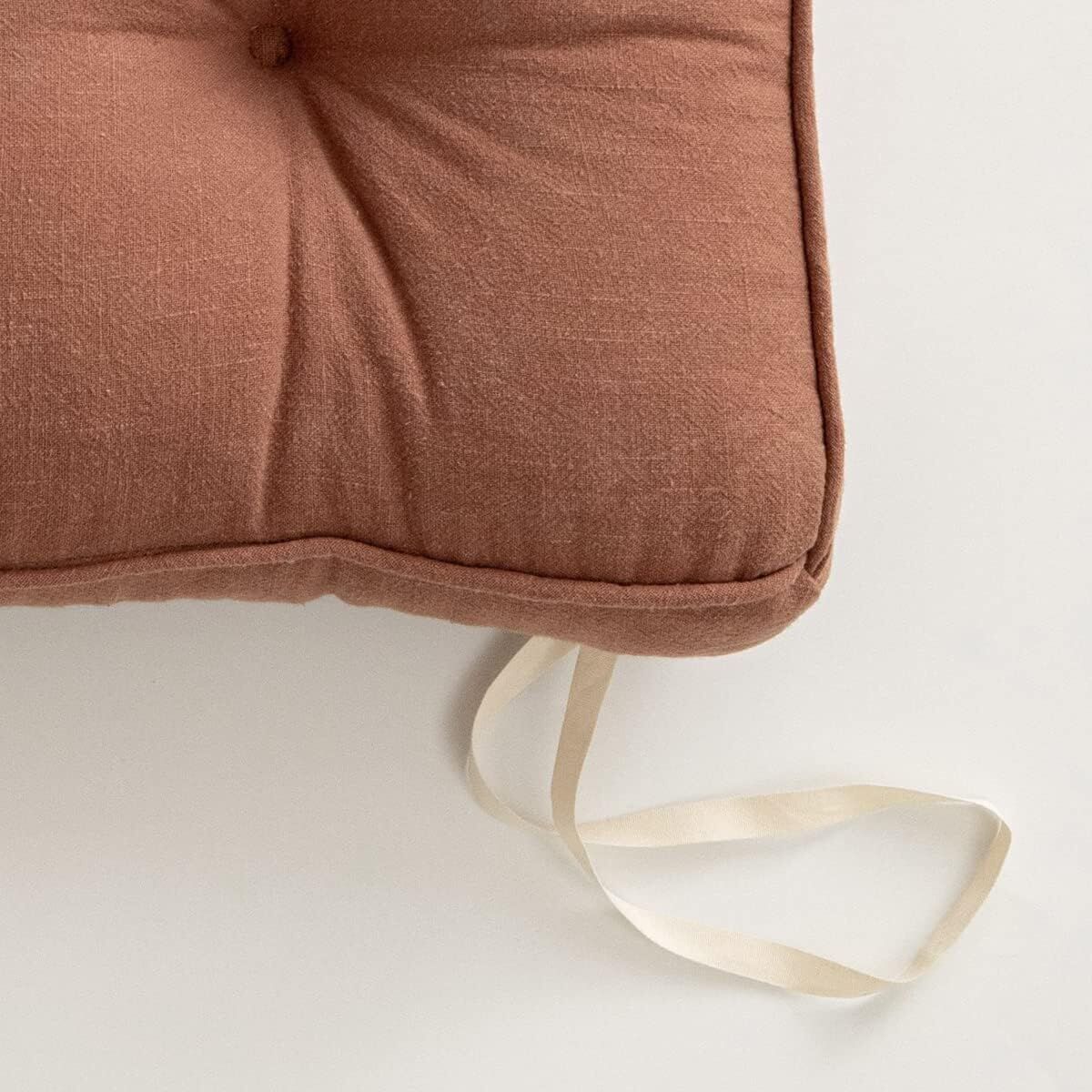 Brown cushion with a ribbon on a white background