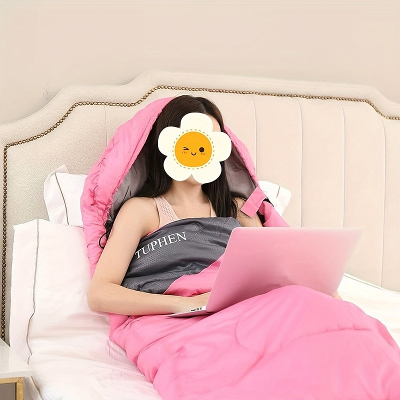 Person lying in bed using a laptop under a pink blanket with a visible brand name.