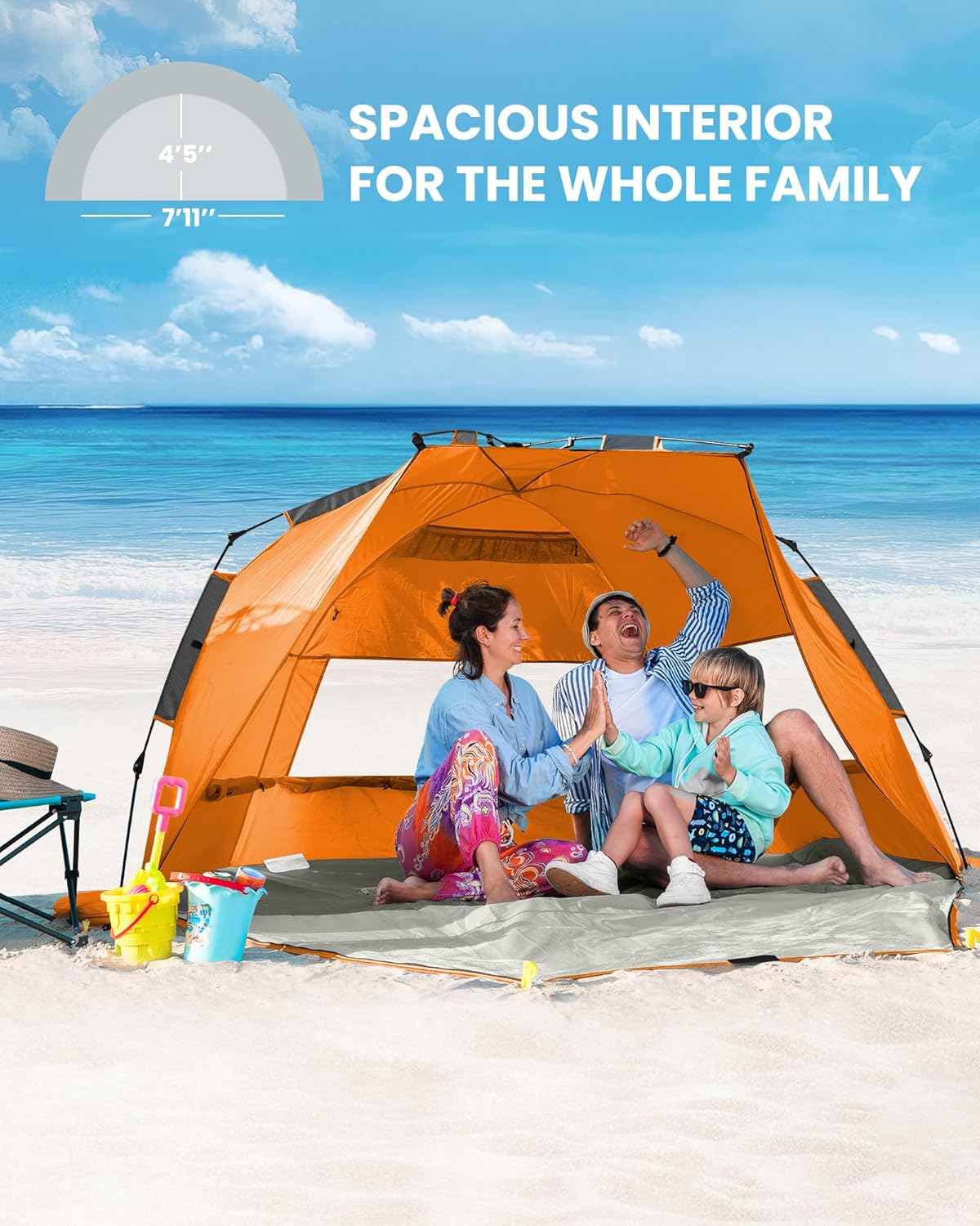 Family sitting inside a large orange tent on a sandy beach with ocean view