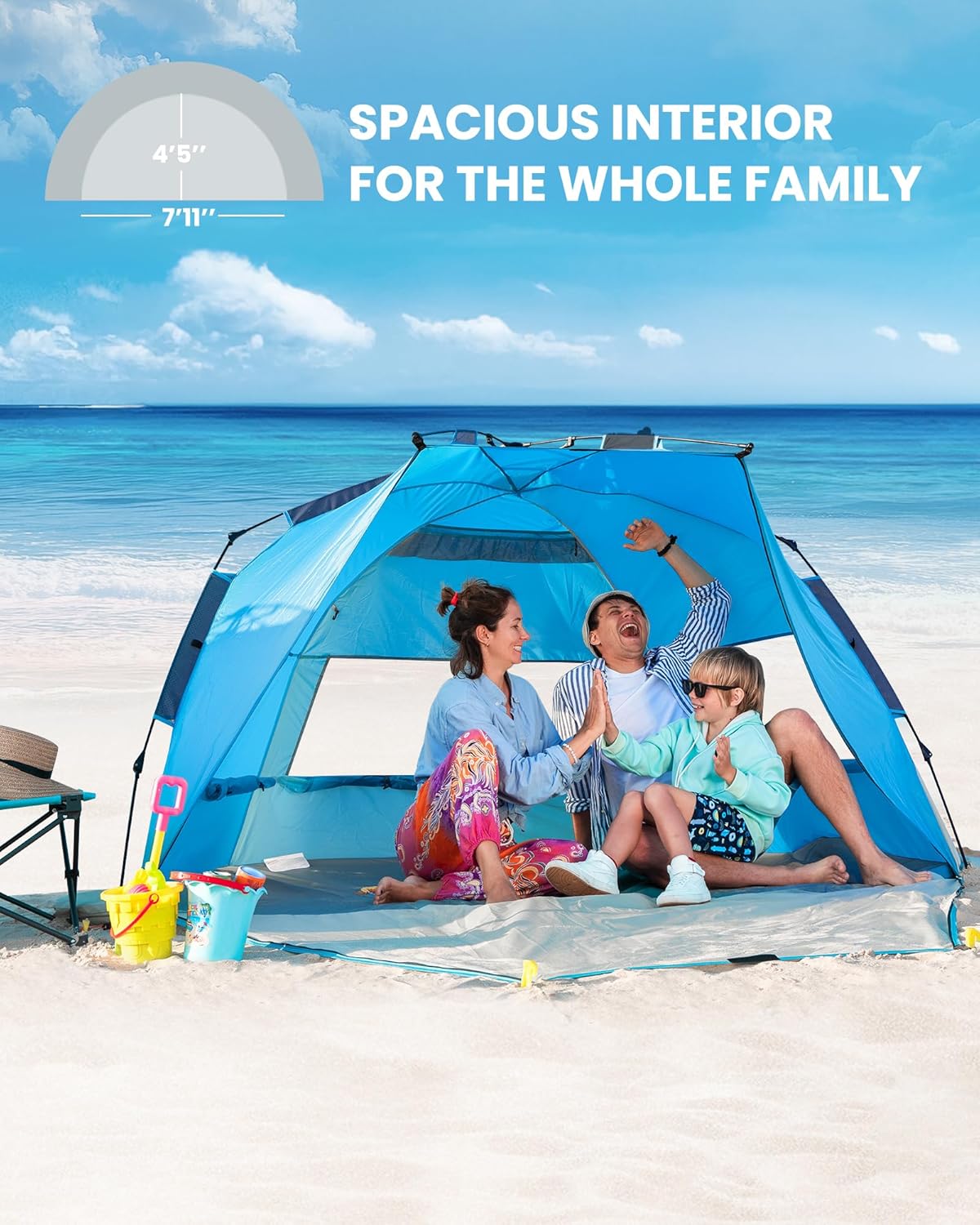 Family sitting inside a blue beach tent on a sandy beach with ocean view