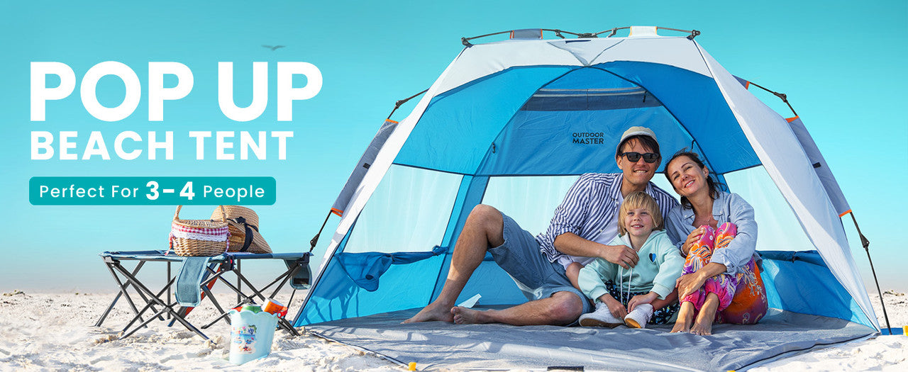 Family sitting under a pop-up beach tent on a sandy beach with a clear blue sky.