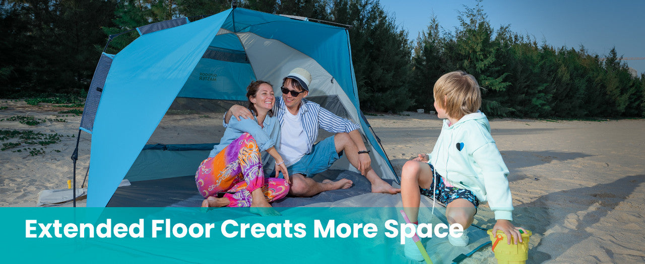 Family sitting under a blue and white beach tent on a sandy beach with text 'Extended Floor Creates More Space'.