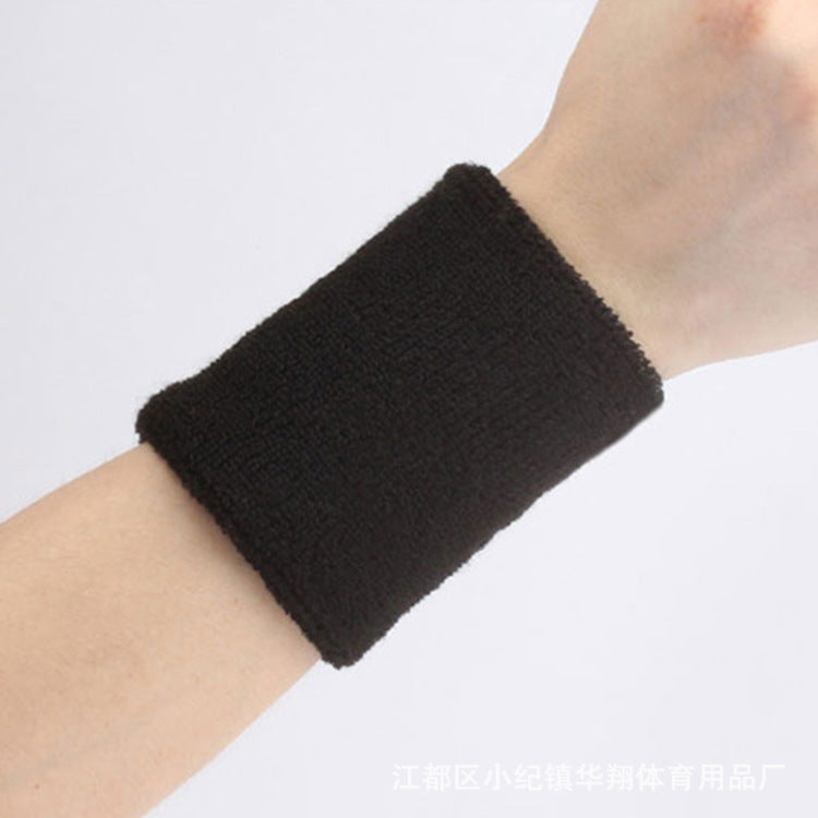 Black wristband on a person's wrist against a white background