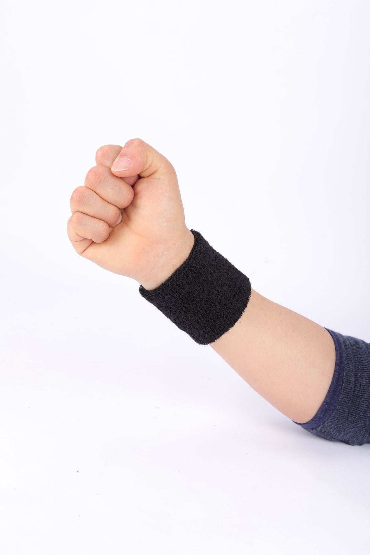 Black wristband on a person's wrist against a white background