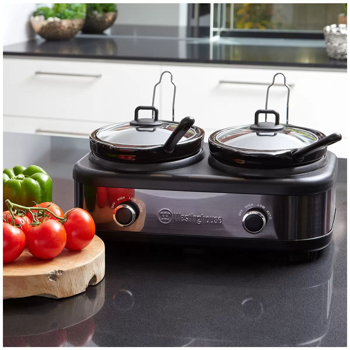 Double hot plate with Westinghouse logo on a kitchen counter with vegetables.