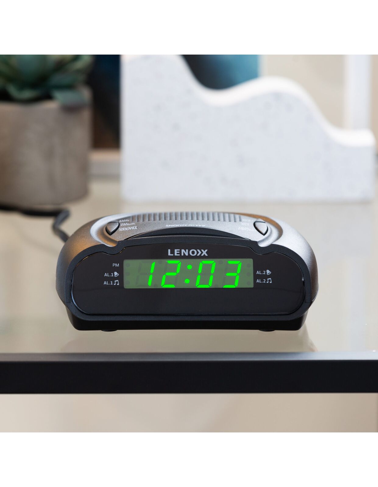 Lenox digital clock on a surface with a blurred background