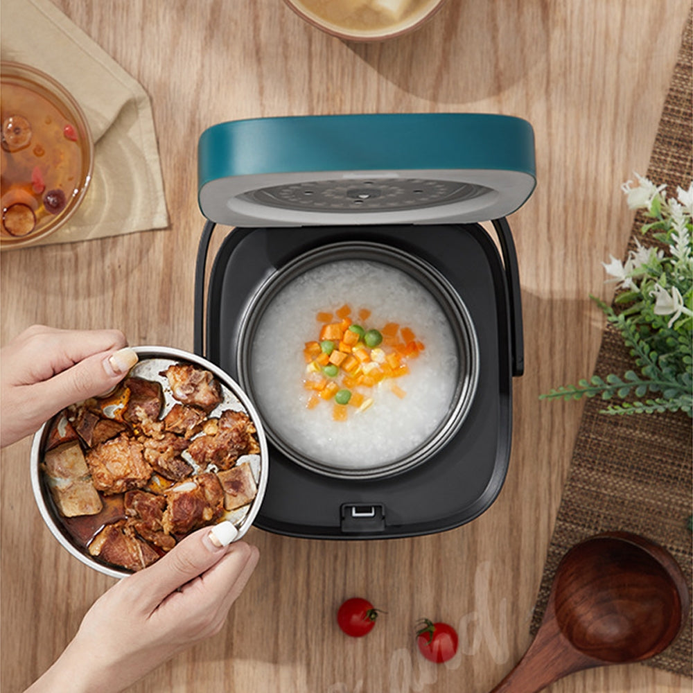 Multicooker with rice and vegetables on a wooden table, hand holding a bowl of food.
