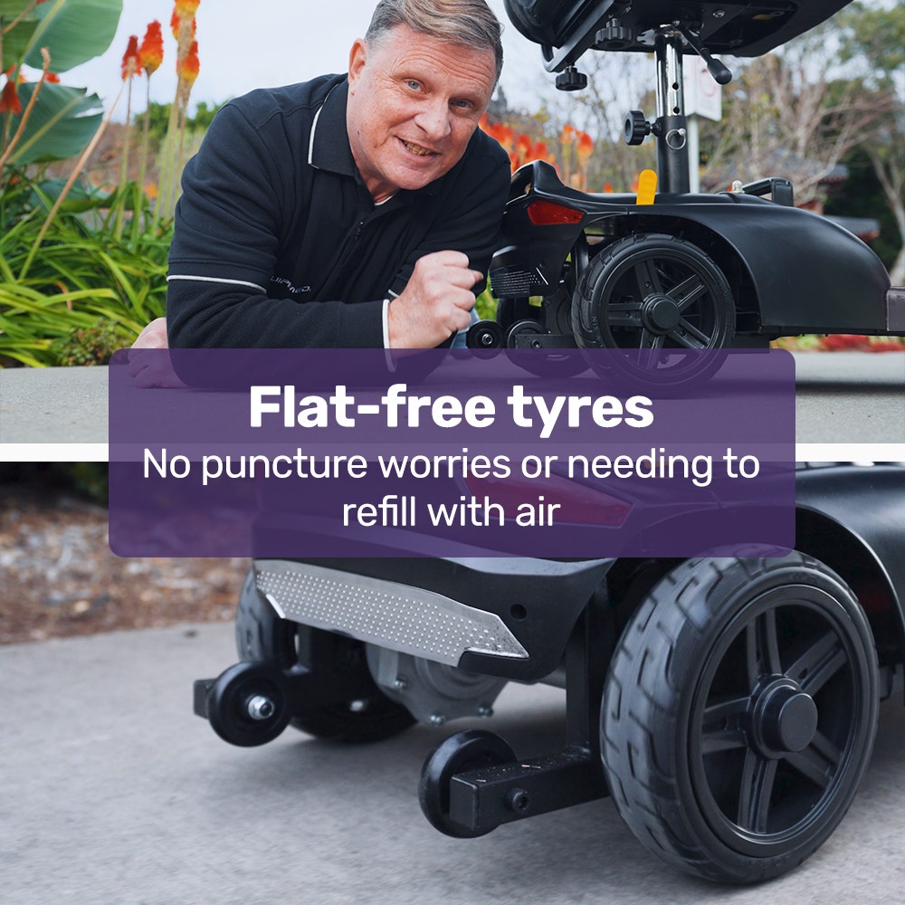 Man interacting with a vehicle featuring flat-free tyres, with promotional text overlay.