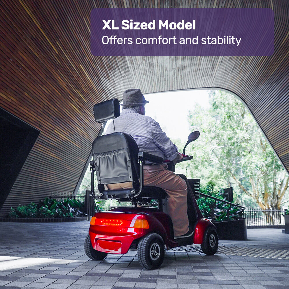 Person using a red XL sized mobility scooter in an outdoor setting.