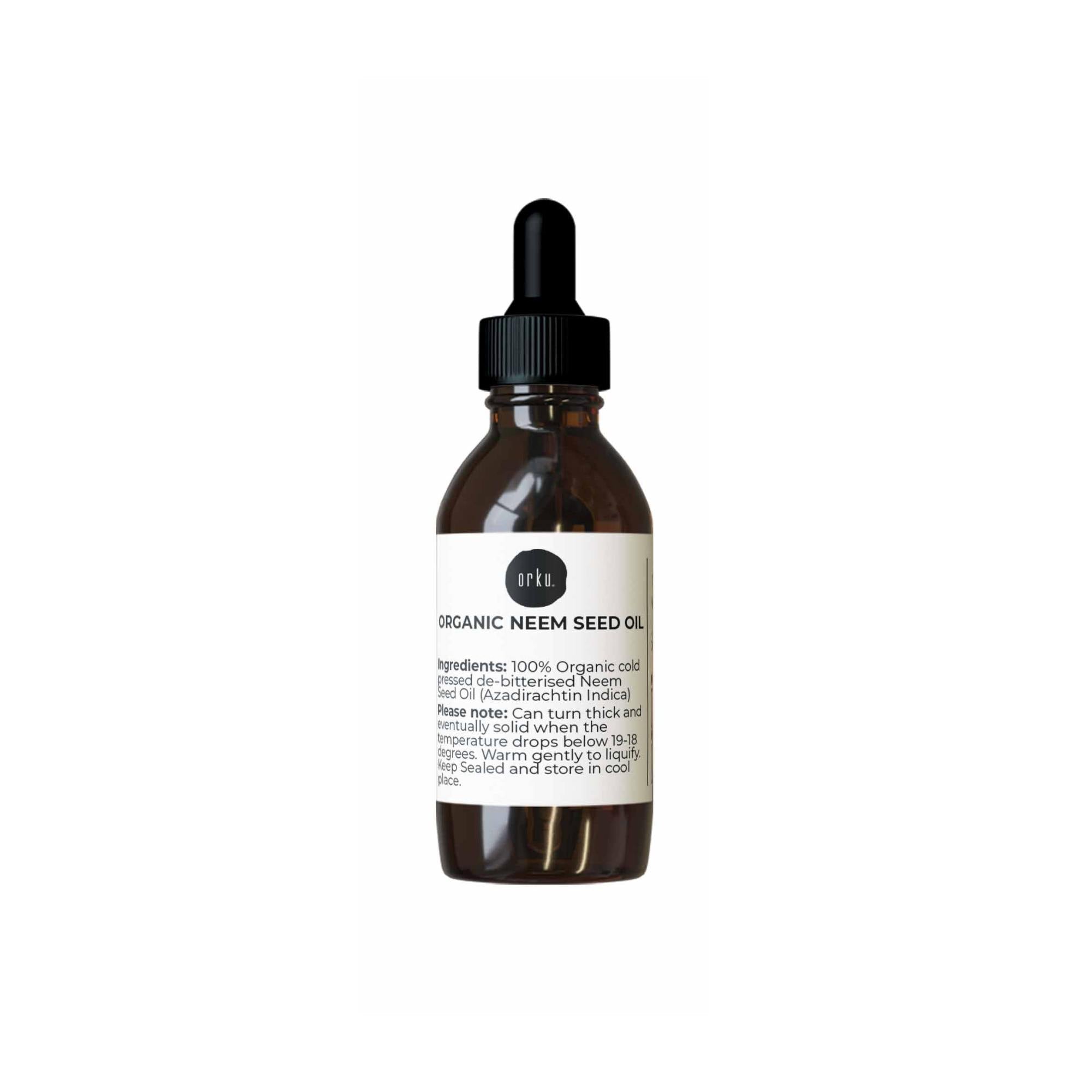 Bottle of organic neem seed oil with a dropper on a white background