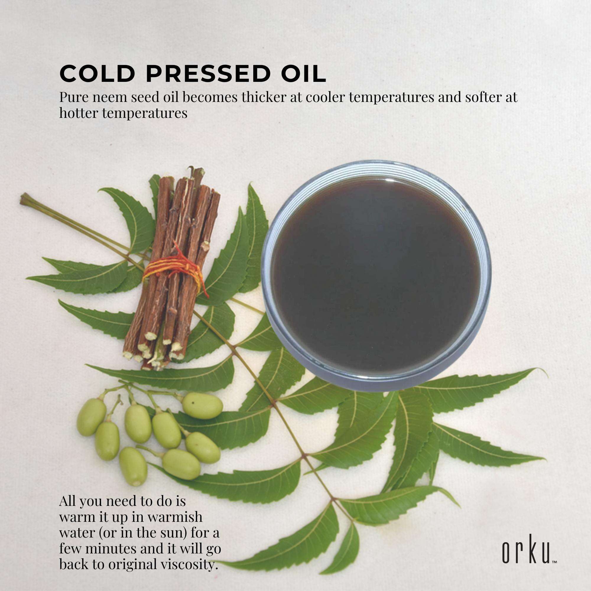 Cold pressed oil with neem leaves, seeds, and sticks on a light background