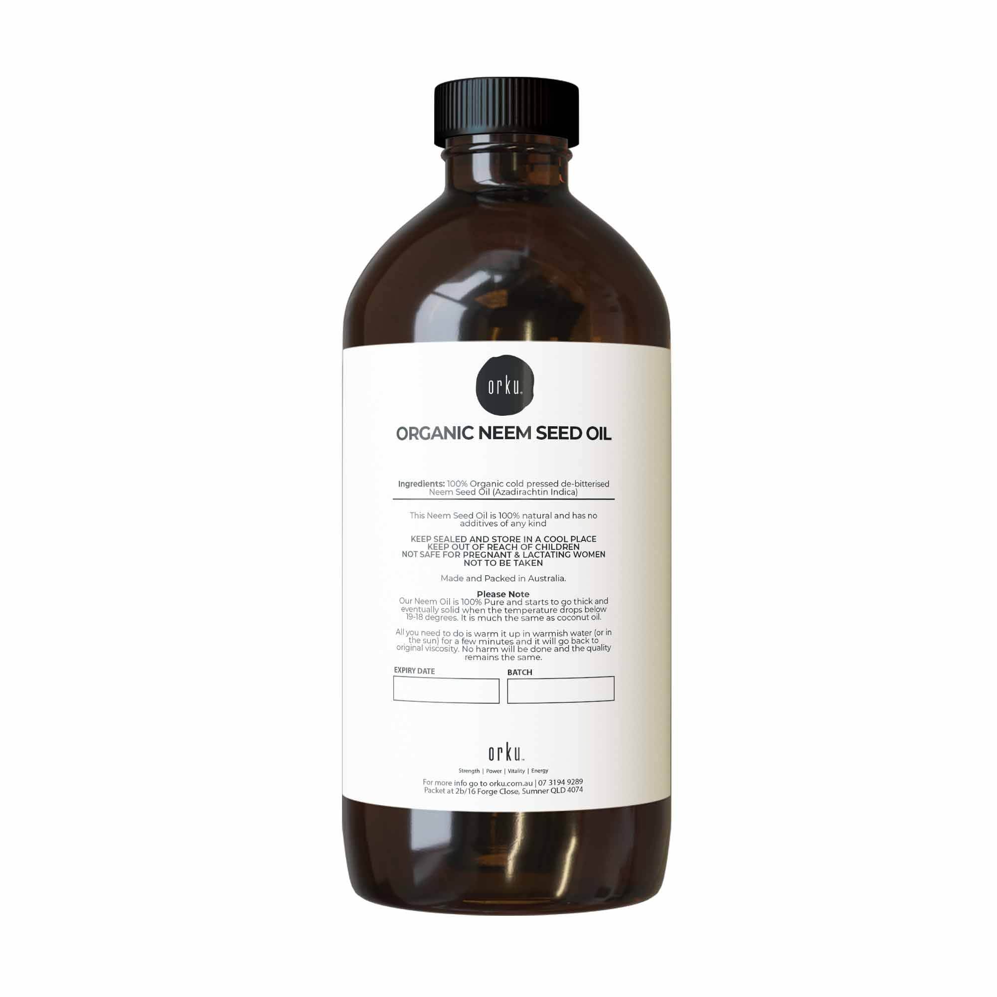 Brown bottle of organic neem seed oil with a label on a white background