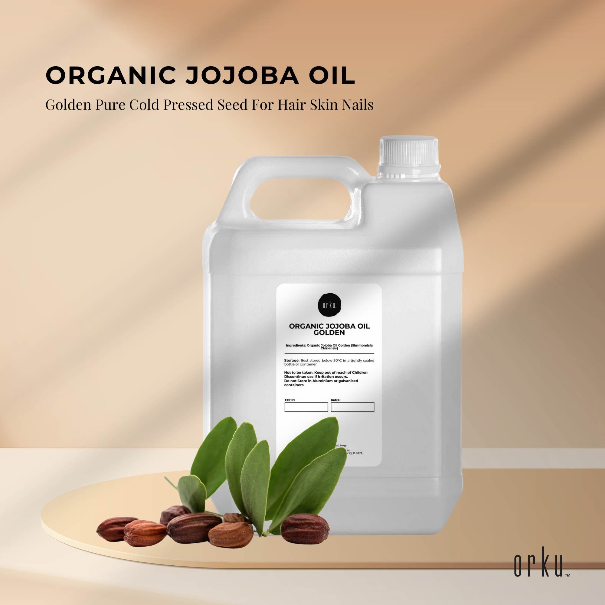 Container of organic jojoba oil with seeds and leaves on a beige background