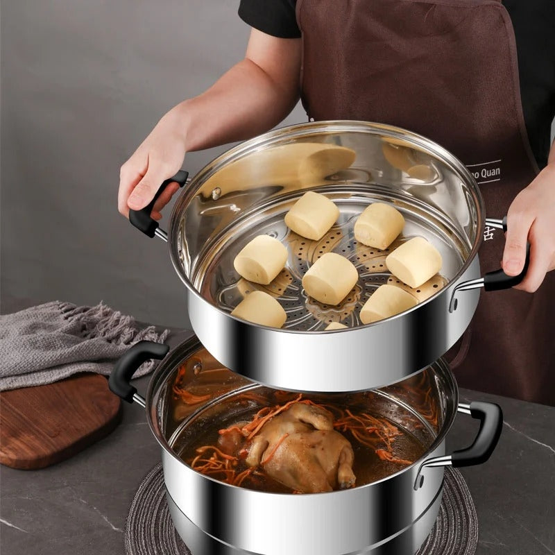 Stainless steel steamer pot with food on a dark surface