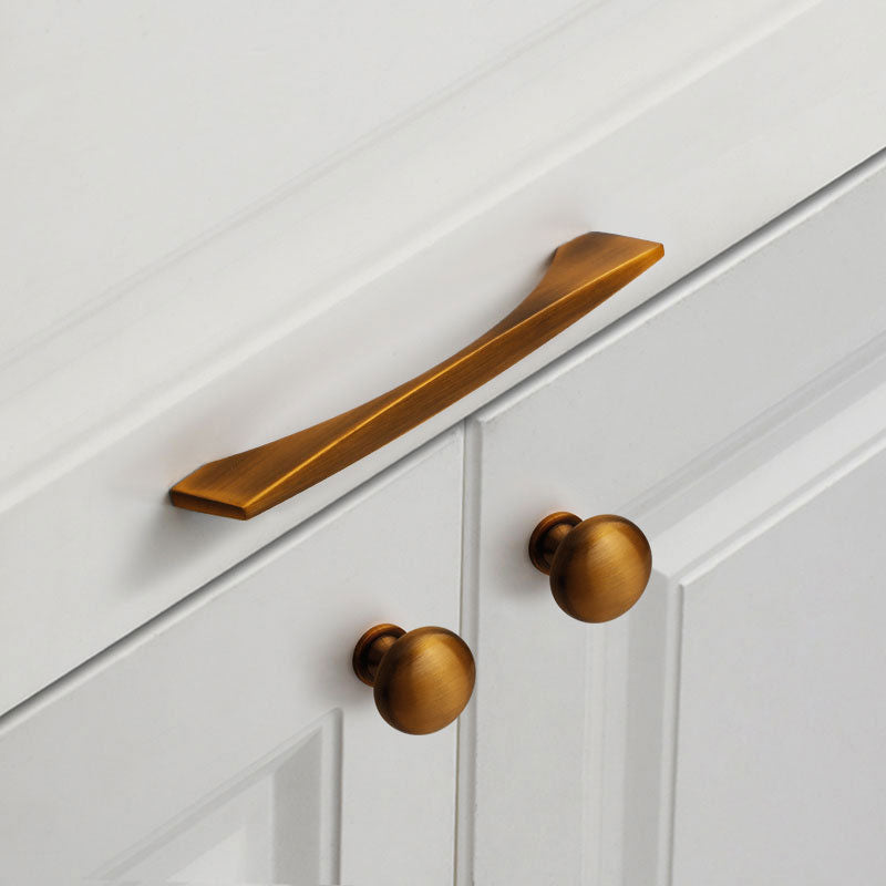 Brass cabinet handle and knobs on a white cabinet