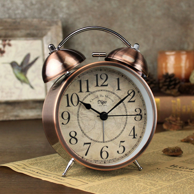 Vintage-style alarm clock with copper finish on a textured surface