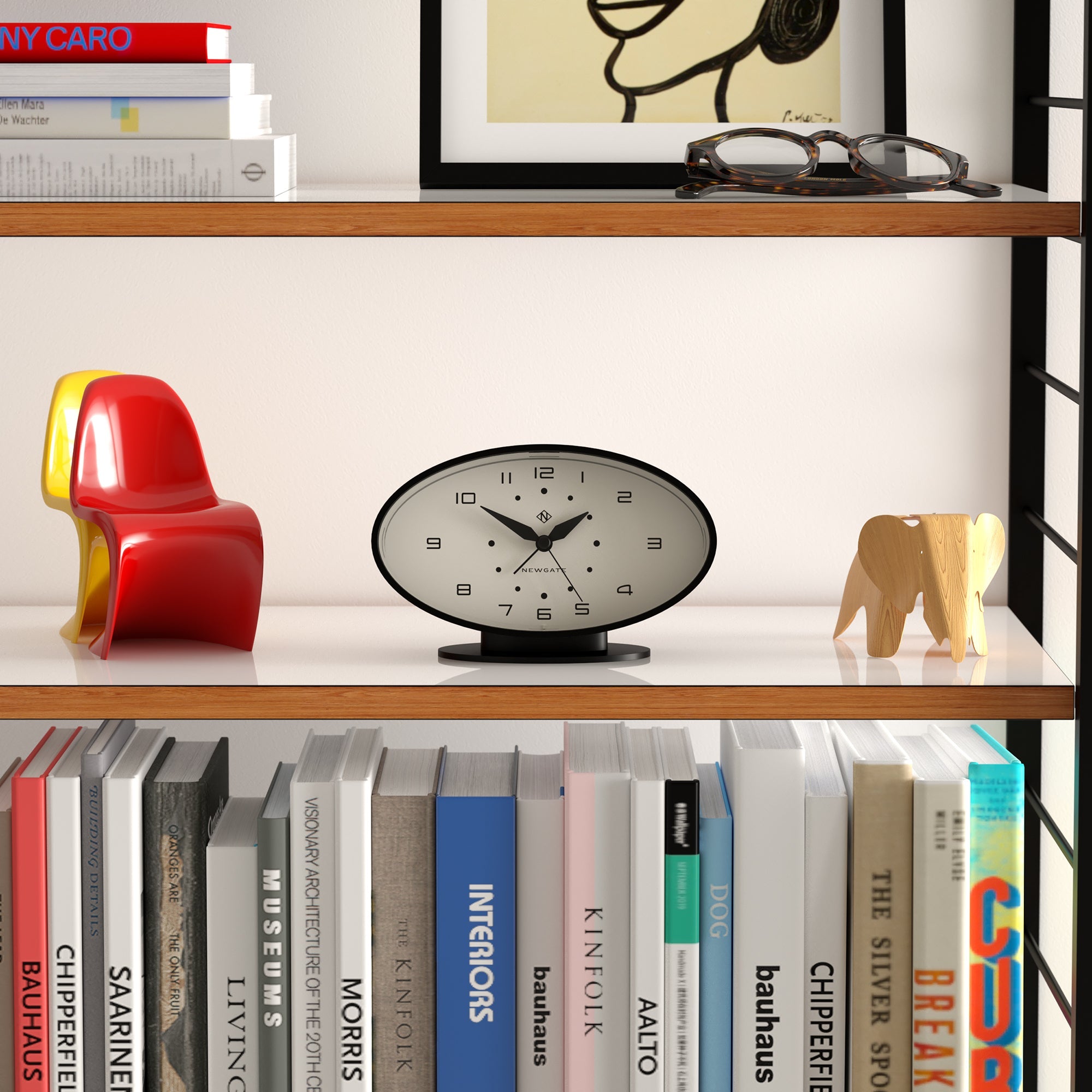 Bookshelf with books, a clock, and decorative items against a white wall.