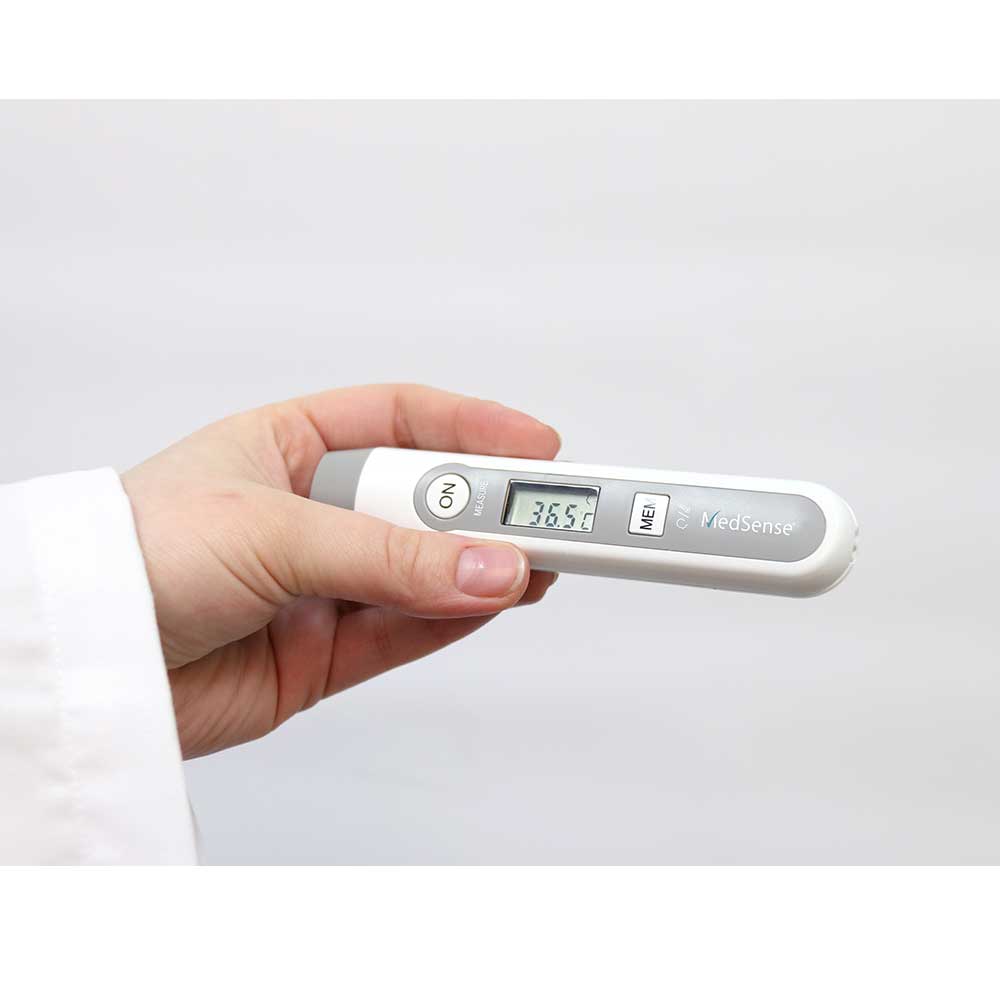 Digital thermometer held in a hand with a white background