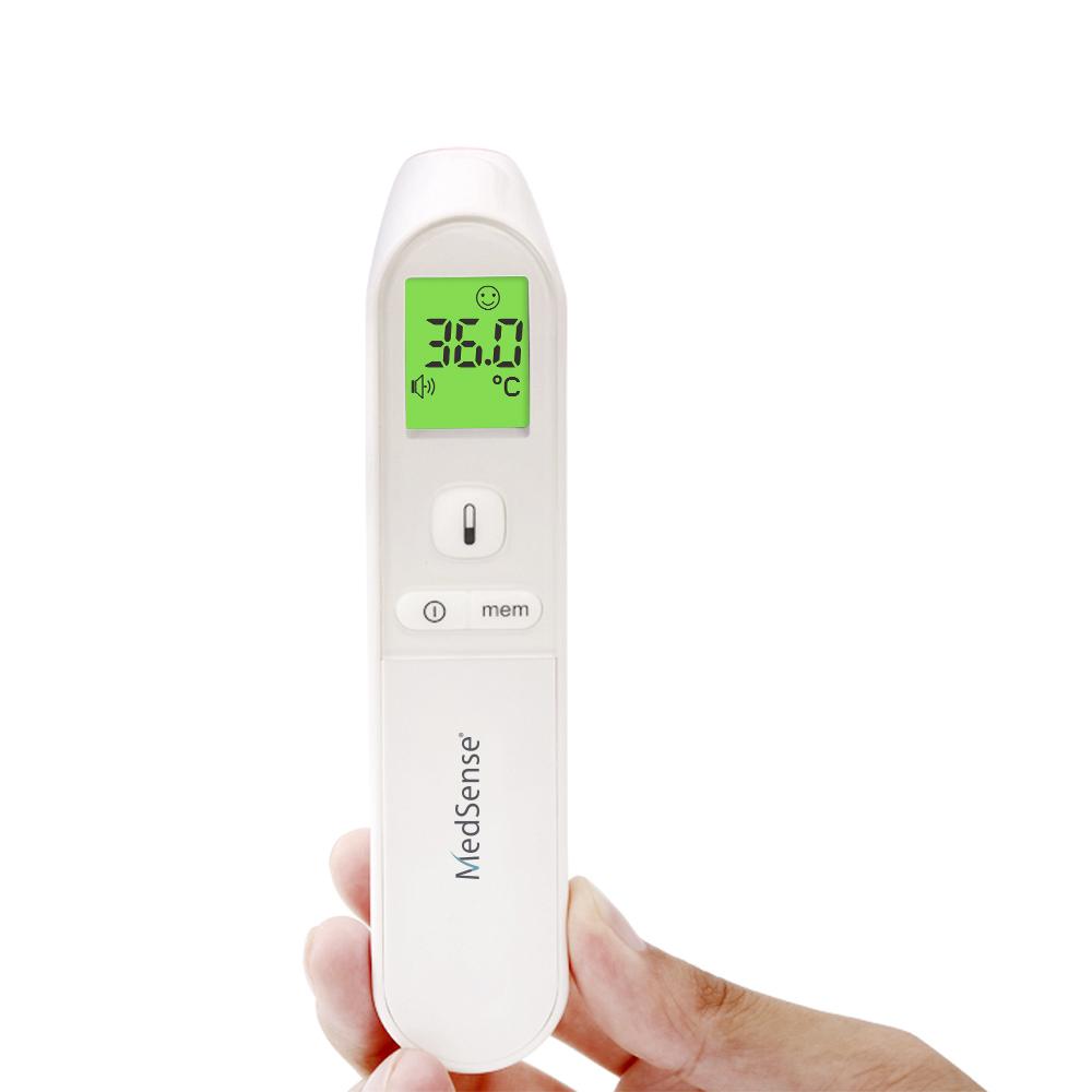 Digital thermometer with a green display held by a hand on a white background