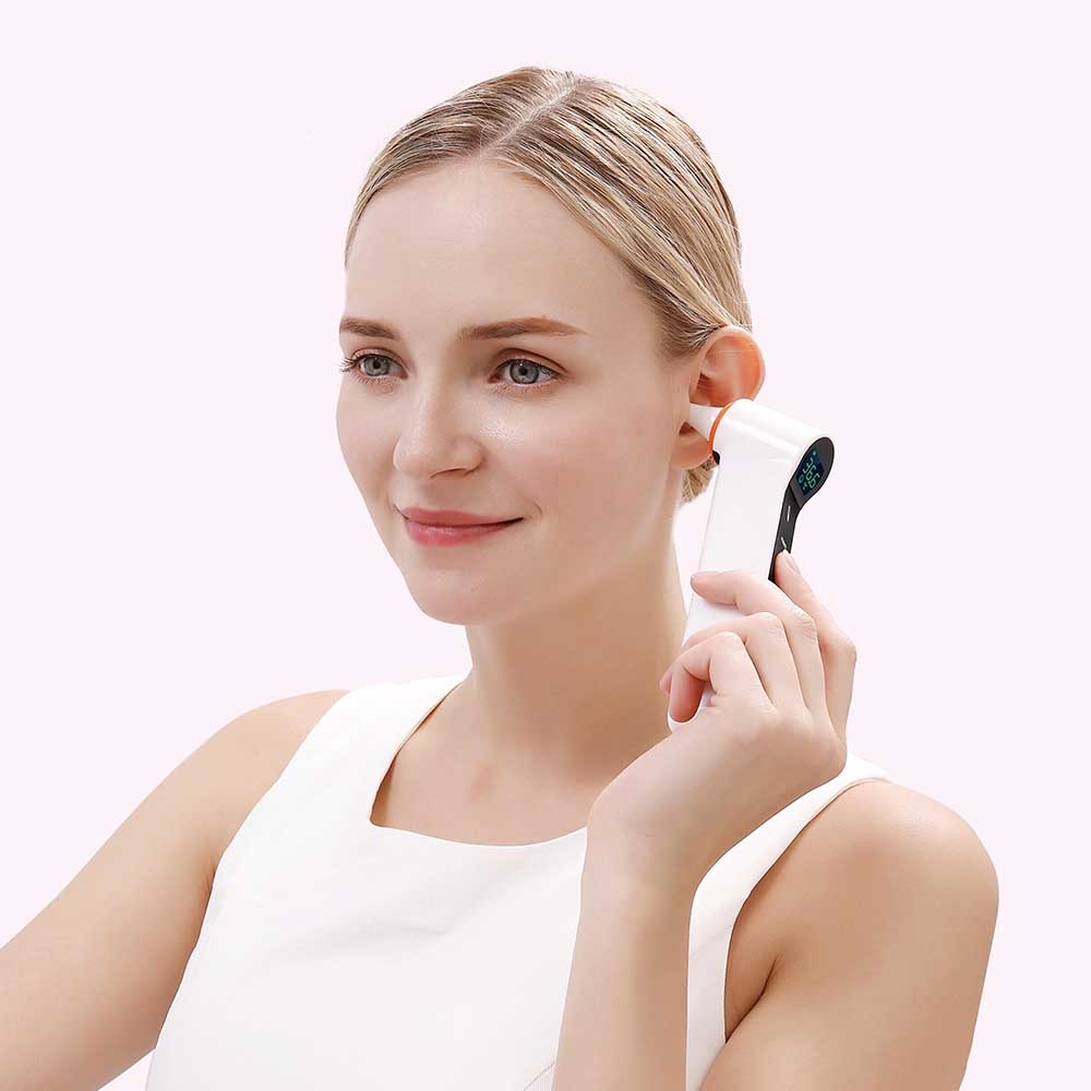 Woman using an ear cleaning device on a plain background
