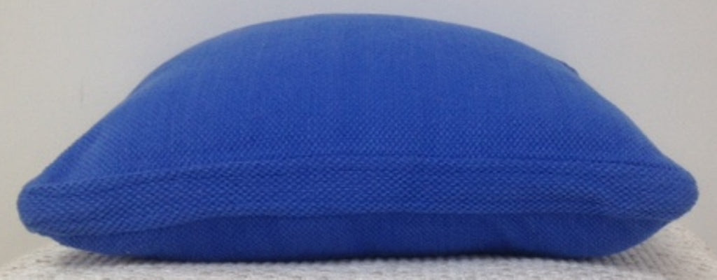 Blue pillow on a textured surface with a neutral background