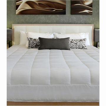 Bed with white comforter, gray pillows, and decorative pillows against a wall with abstract art.