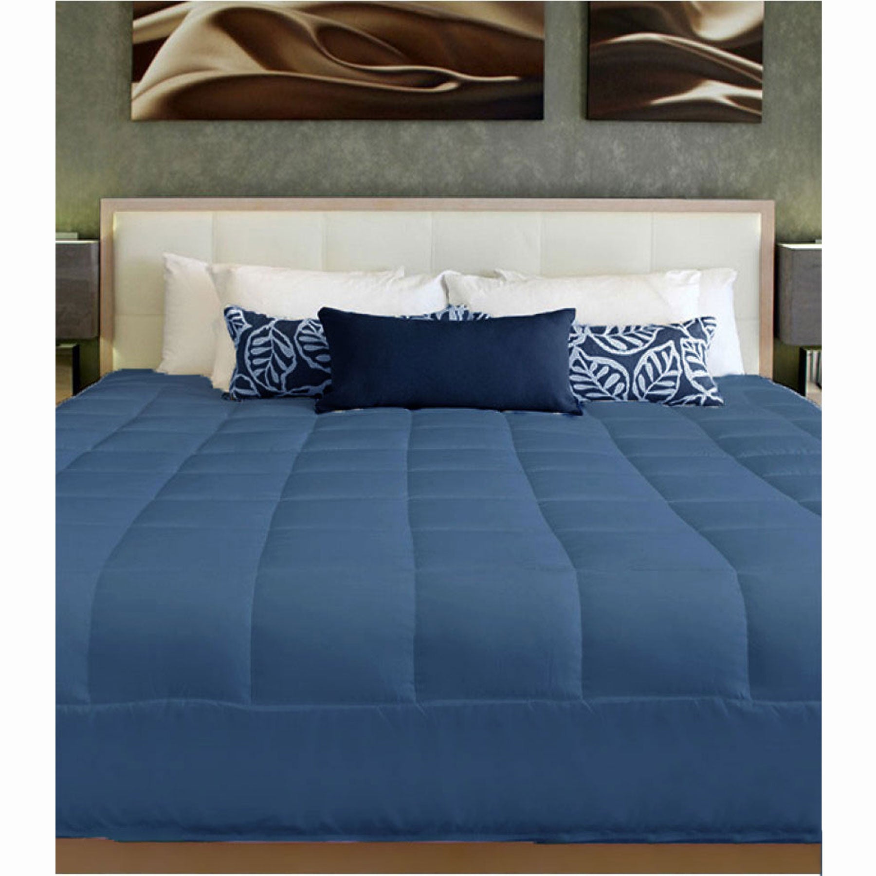 Blue comforter on a bed with decorative pillows and abstract wall art.