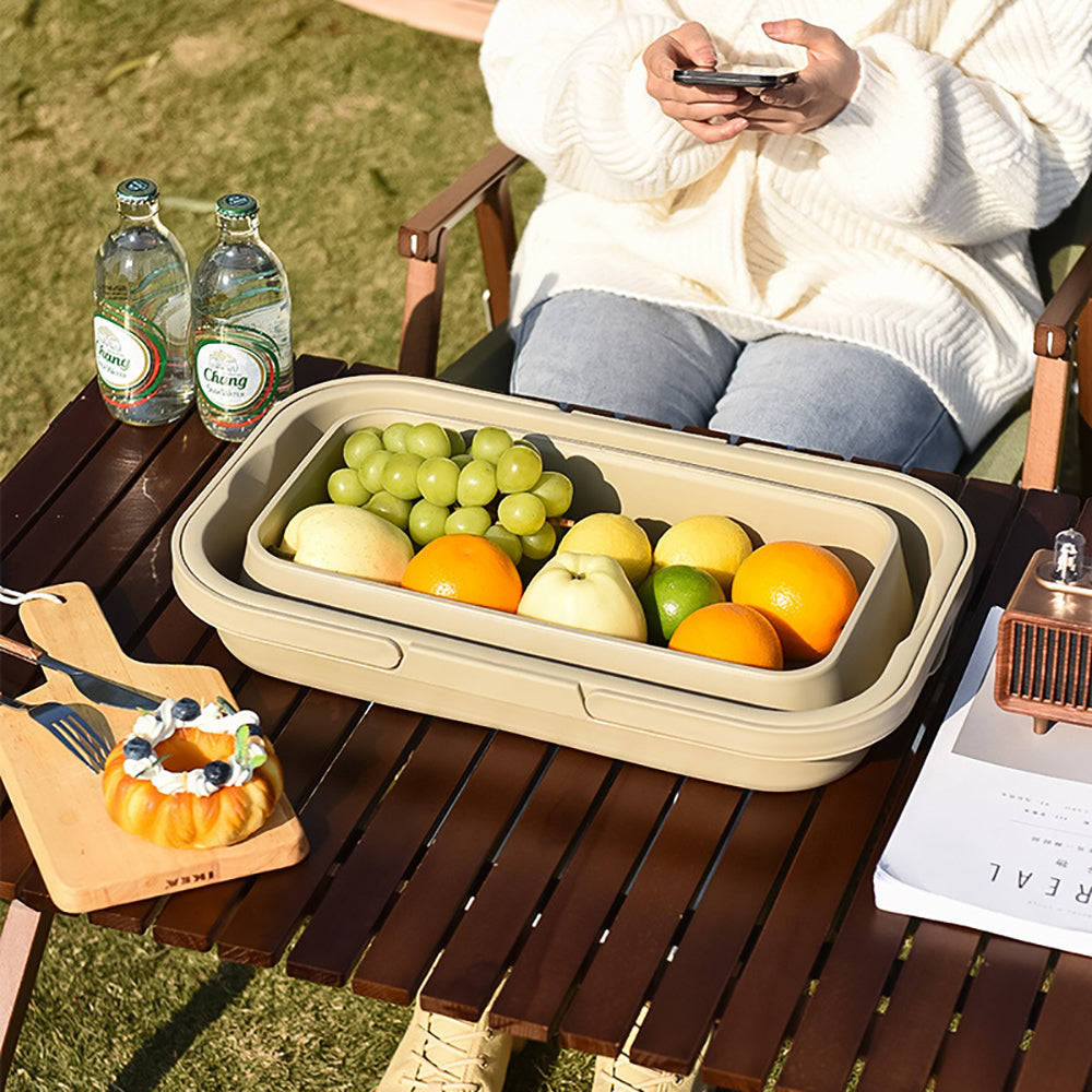 Collapsible fruit basket with fruits on a picnic table outdoors