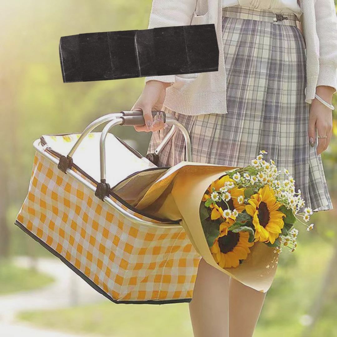 Person holding a yellow checkered bag with flowers outdoors